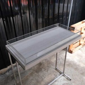高大的木制产品展示托盘，固定在透明的亚克力框架上。产品货架、钢腿架