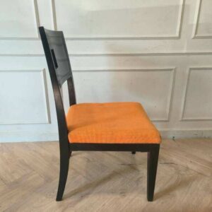 木椅配有橙色布垫，设计精美，靠背上有一个孔。