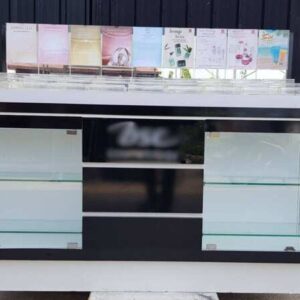 玻璃展示柜，黑色木质化妆品展示柜，配有两扇玻璃门和三扇木门。